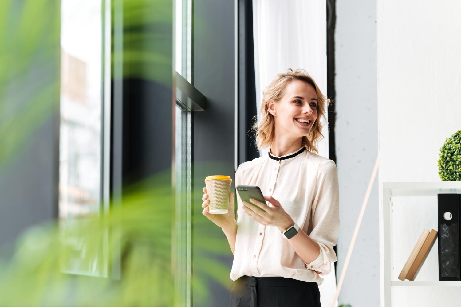 woman office worker on mobile with coffee