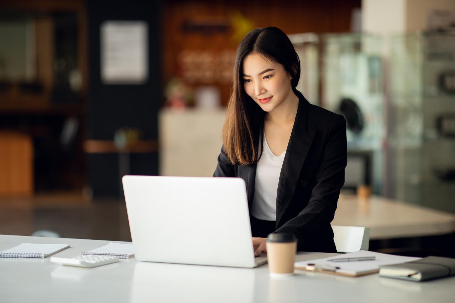 business lady standing at desk with laptop