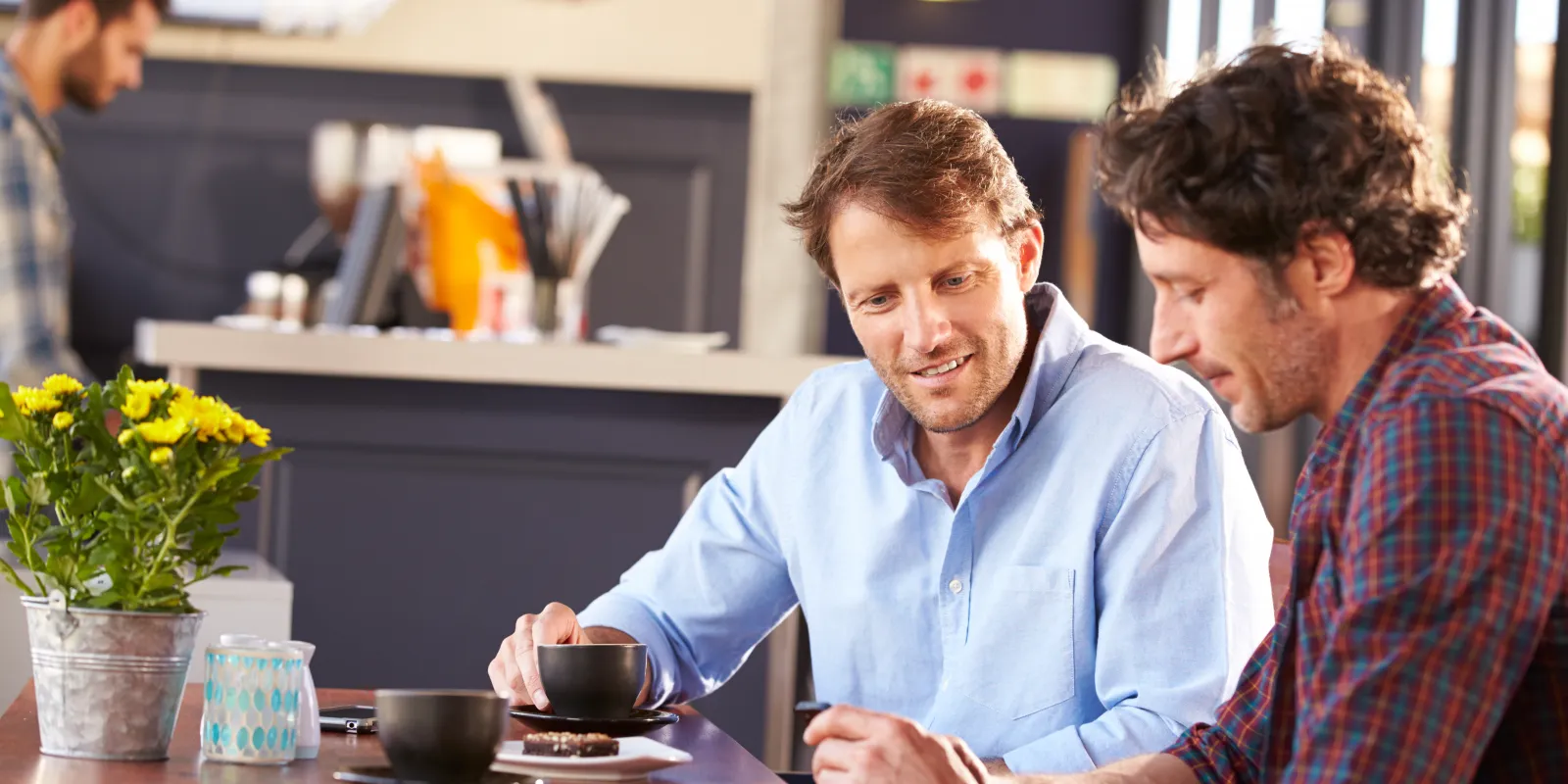 two men in cafe drinking coffee