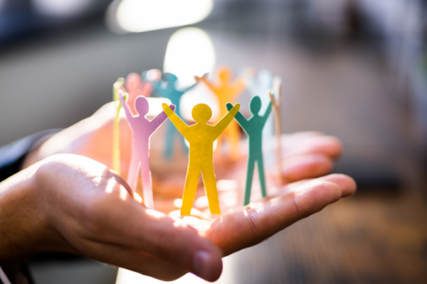 Paper cut outs of people holding hands in an circle